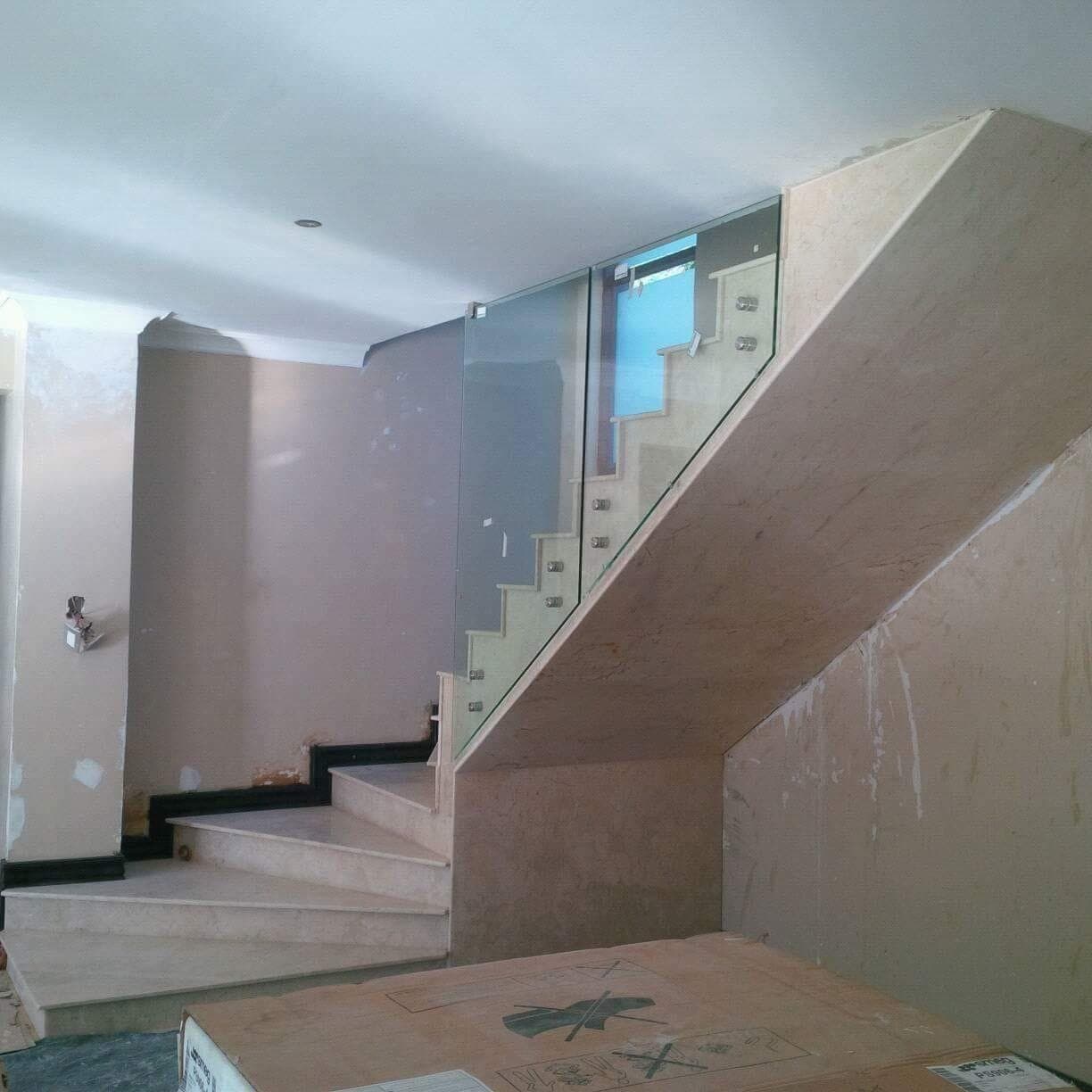 Curved staircase with glass balustrade panels held by clamp fixings