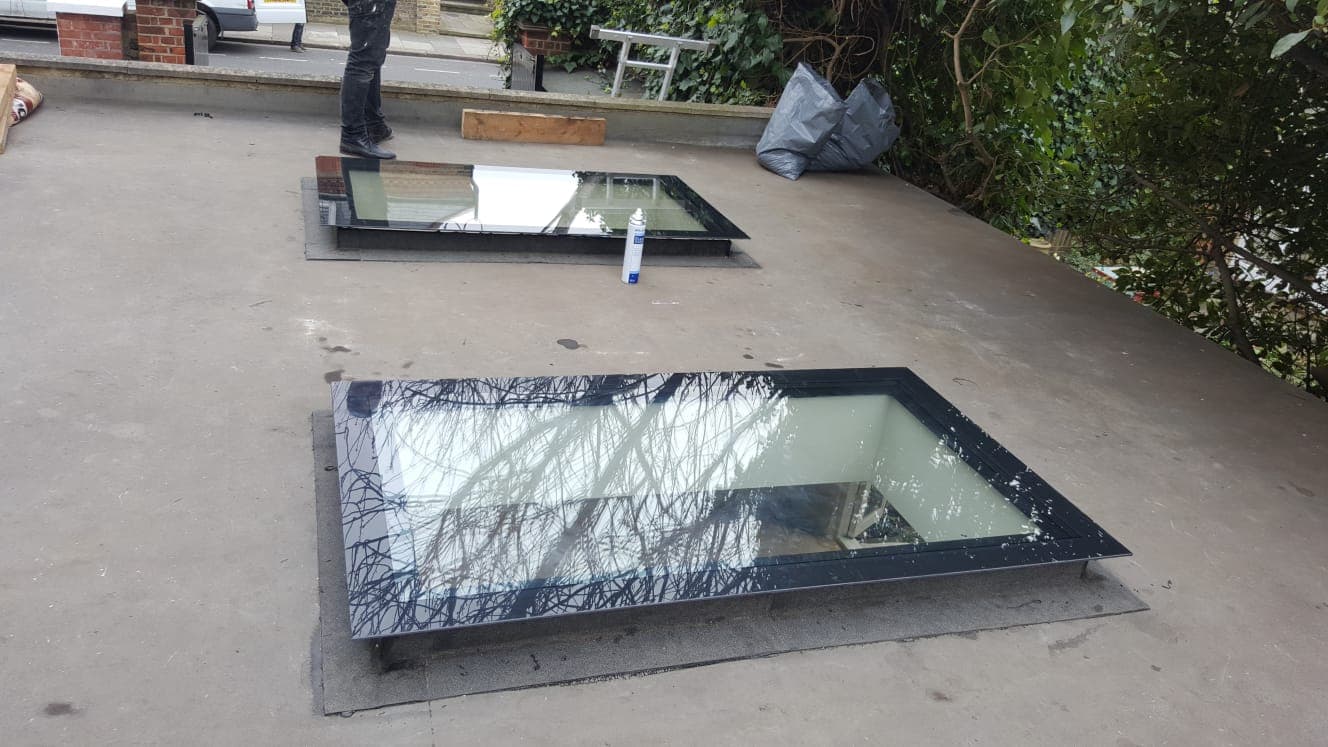 Rooflights set into a flat roof with a garden beyond