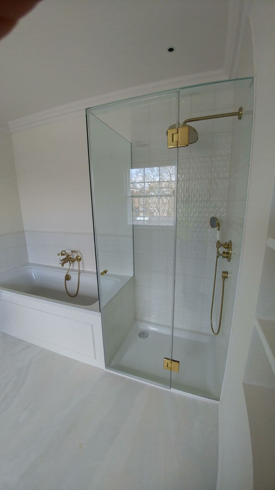 Over-bath shower screen with a return panel and metal fittings, with a window inside the enclosure