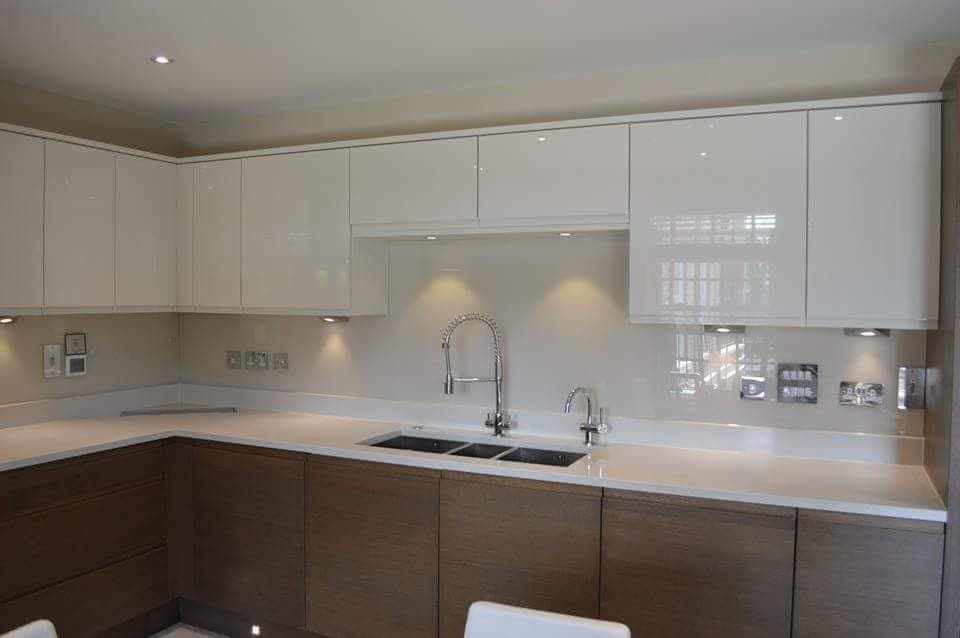 Cream coloured glass splashback in a kitchen with timber base units and a chrome mixer tap