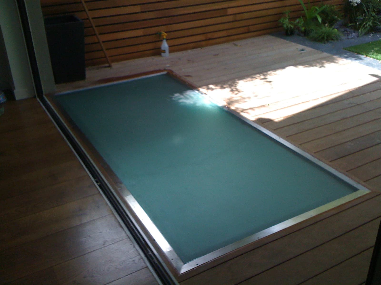 A large walk-on glass panel set flush into timber decking over a lightwell